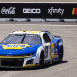 Blue and yellow race car competing on a professional race track.