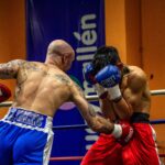 Two boxers in mid-action during a heated match, showcasing strength and skill.