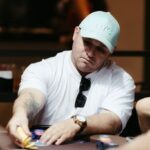 A focused poker player strategizes during an intense casino game. Indoor setting with poker chips and cards.